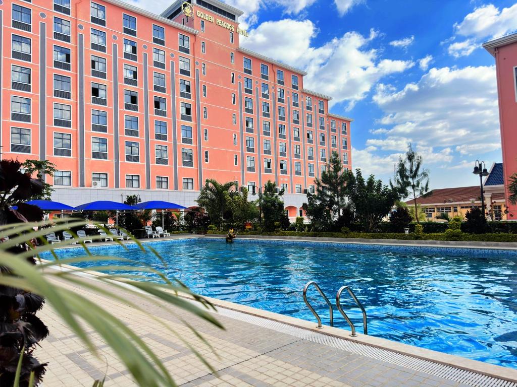 a large pool in front of a large pink building at Golden Peacock Hotel Blantyre in Blantyre