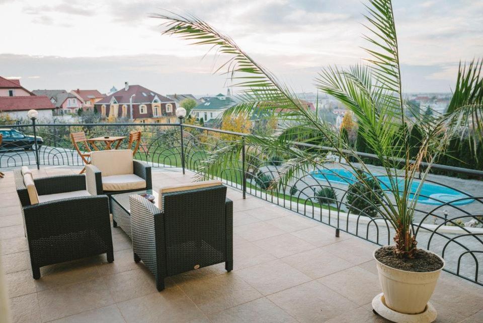 un balcone con sedie, piante e piscina di APARTHOTEL Panoramis Residence a Oradea