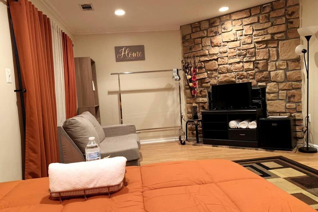 sala de estar con pared de piedra en Modern Comfort Stays, en Alexandria