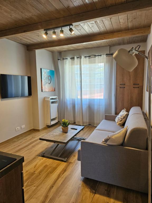 uma sala de estar com um sofá e uma televisão em Moda Apartments 69 em Sestriere