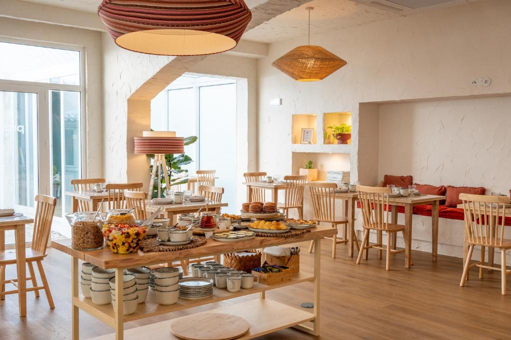 Cette chambre comprend une table avec de la nourriture. dans l'établissement Praia FLH Hotels Ericeira, à Ericeira