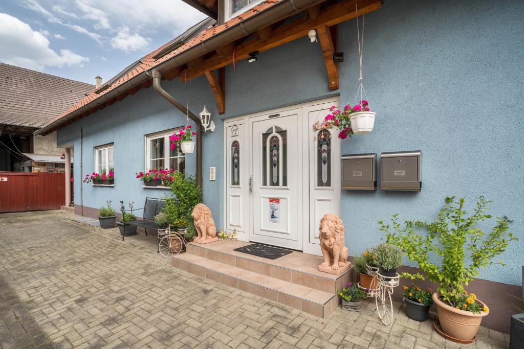 a blue house with a white door and some plants at Ferienwohnung Schläfer in Kappel-Grafenhausen