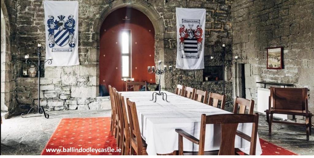 Pokój z dużym stołem z krzesłami i flagami w obiekcie Ballindooley Castle w Galway