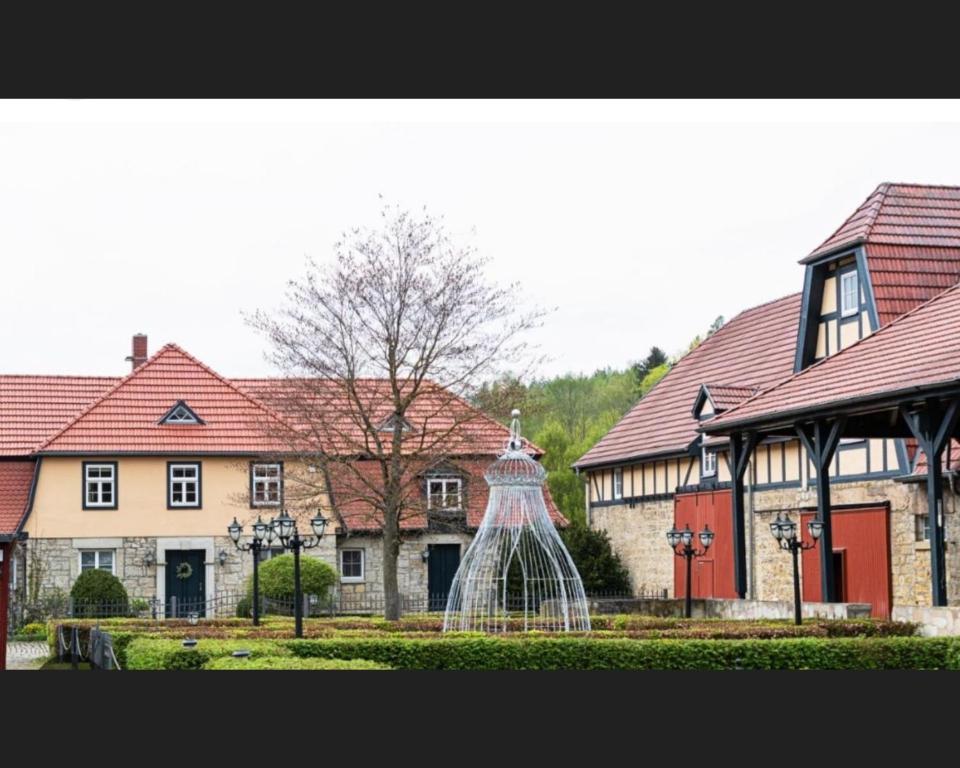 巴特贝尔卡Hotel Henriettenhof Weimarer Land, Weimar-Bad Berka的院子中间有雕像的建筑物