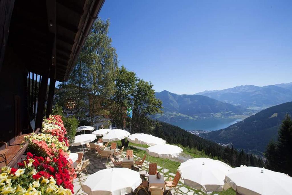 eine Gruppe von Tischen mit Sonnenschirmen auf einem Berg in der Unterkunft Berghotel Blaickner's Sonnalm in Zell am See