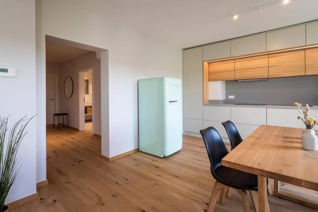 una cucina con tavolo in legno e frigorifero di Renovated 2 Bedroom Apartment with Parking & AC a Lussemburgo