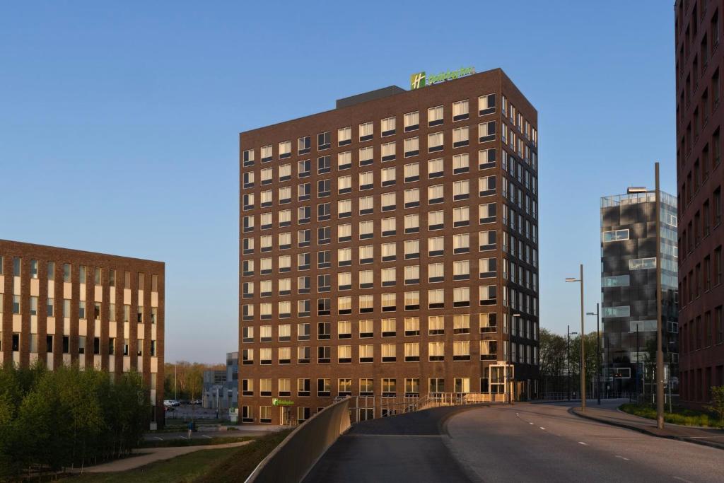 un grand bâtiment dans une rue d'une ville dans l'établissement Holiday Inn - Eindhoven Airport, an IHG Hotel, à Eindhoven