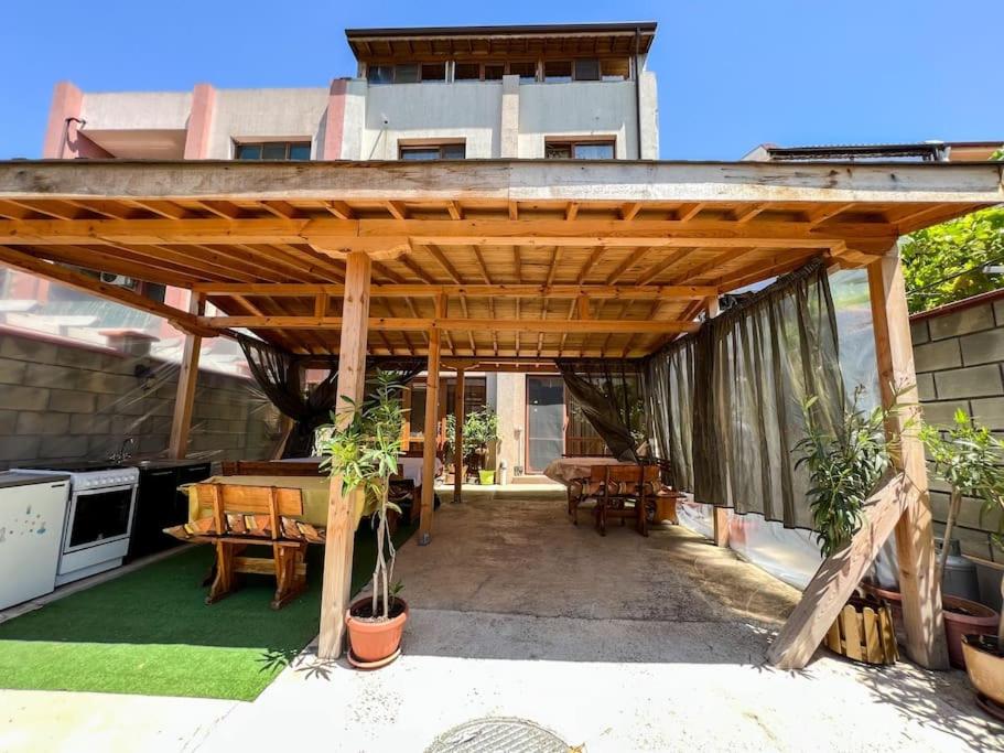 a wooden pergola on a patio with a table at Guest House Italia in Kavarna