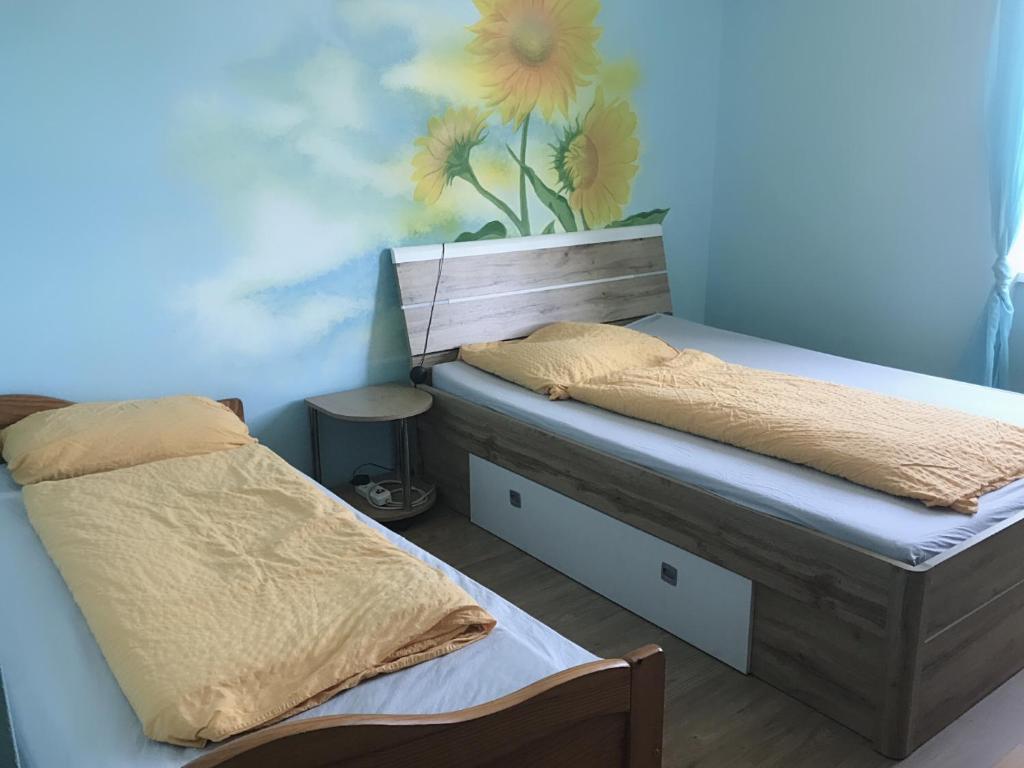 a bedroom with two beds and a painting on the wall at Asia wok gasthof in Ybbs an der Donau