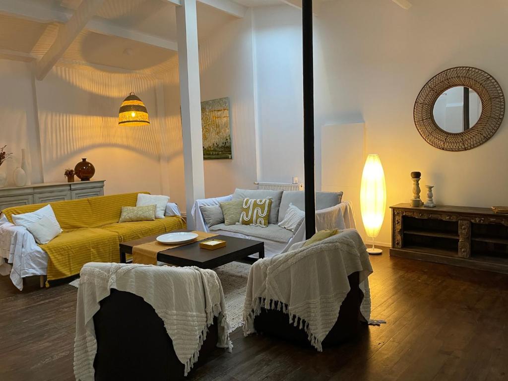 uma sala de estar com um sofá amarelo e uma mesa em Artist's Home - Villa & Private Courtyard - 200m2 em Paris