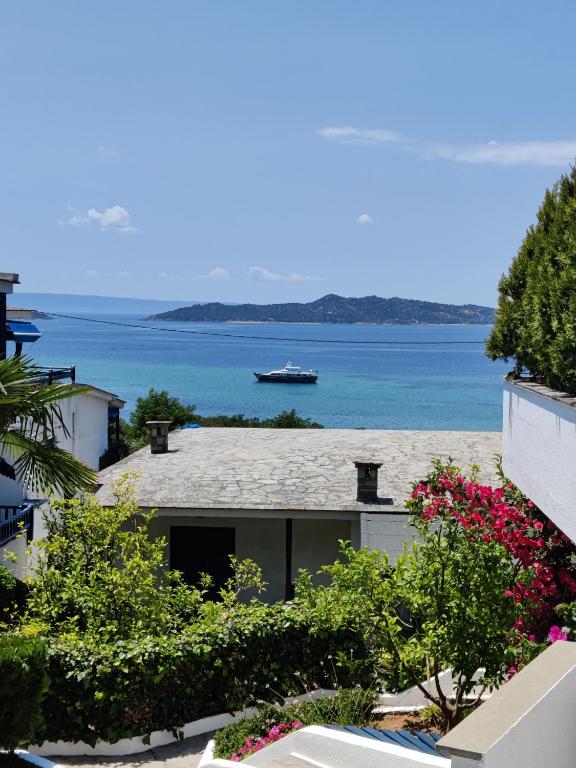 une maison avec vue sur l'eau et un bateau dans l'établissement Brilliance Apartments, à Ouranoupoli