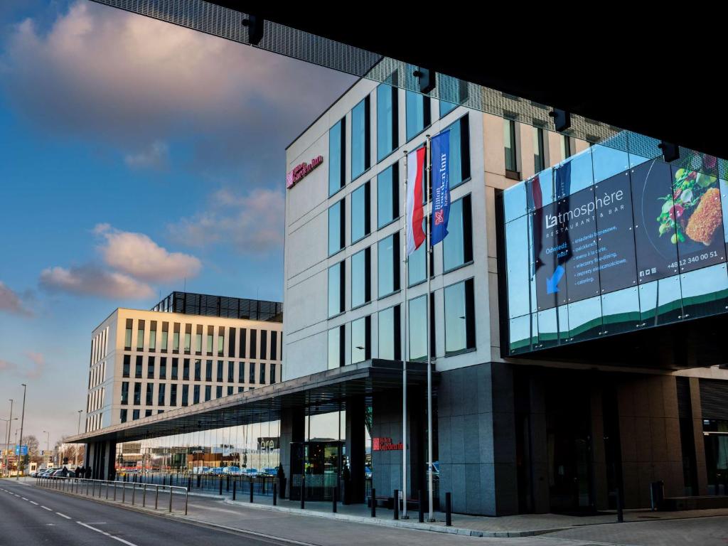 un bâtiment avec un panneau sur son côté dans l'établissement Hilton Garden Inn Krakow Airport, à Cracovie