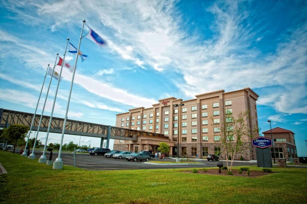 a hotel with flags in front of a parking lot at Hampton Inn Sydney in Sydney