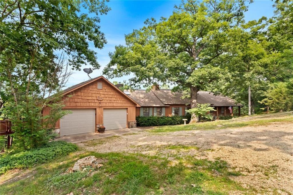 a brick house with a garage and trees at White River Mountain Manor- Million dollar view in Eureka Springs