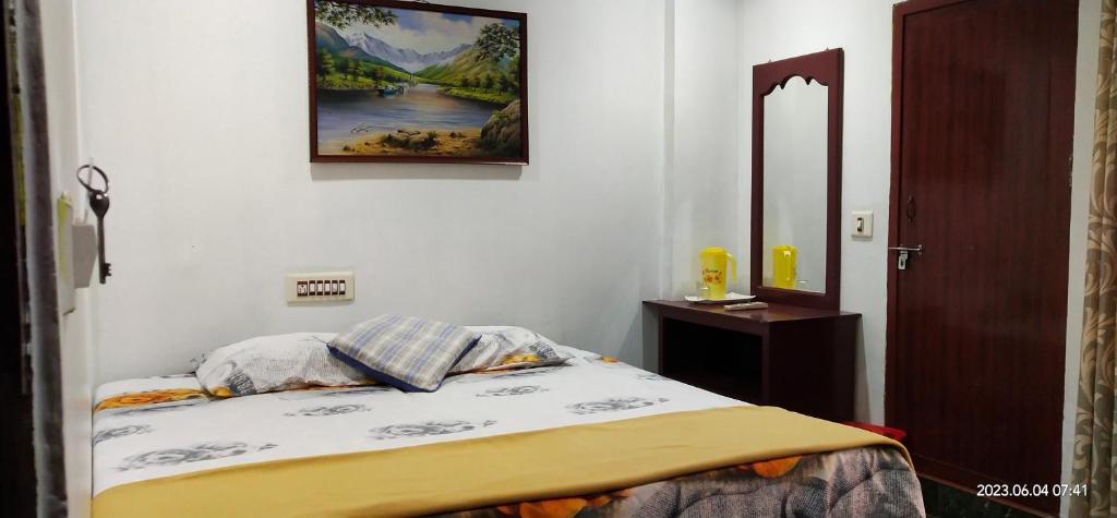 een slaapkamer met een bed en een foto aan de muur bij Floral Homestay in Thekkady