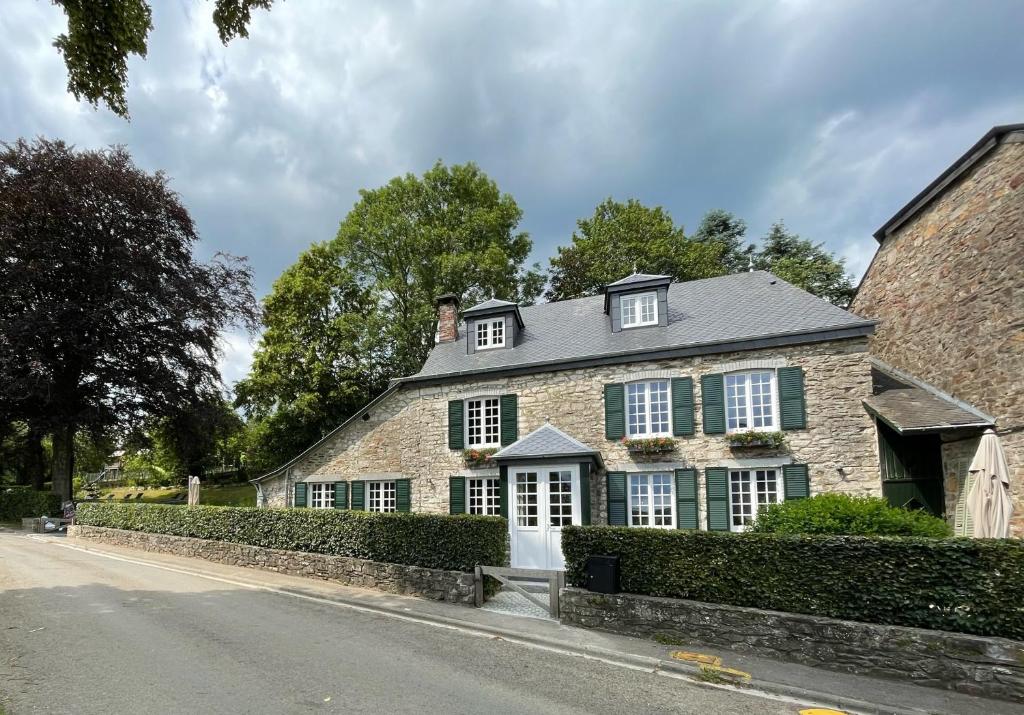 Maison en pierre avec volets verts dans une rue dans l'établissement L'Art de la fugue, à Daverdisse