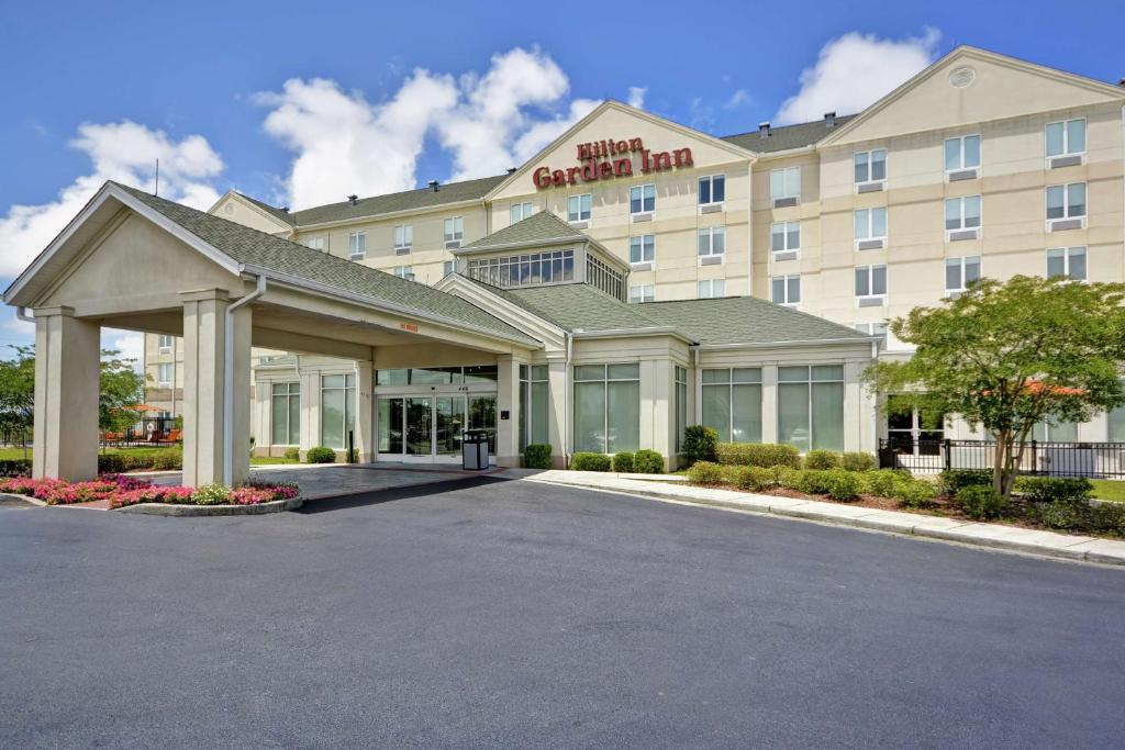 uma renderização da frente de um hotel com estacionamento em Hilton Garden Inn Gulfport - Biloxi Airport em Gulfport