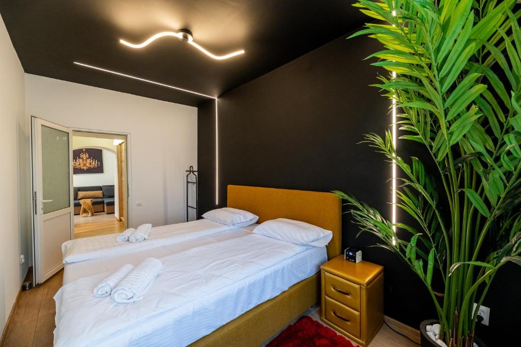 a bedroom with a bed and a large plant at Demiani House in Sibiu