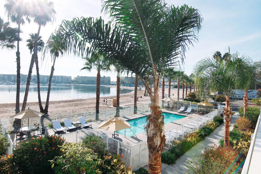 a resort with a pool and palm trees and a beach at Jamaica Bay Inn Marina Del Rey Tapestry Collection by Hilton in Los Angeles