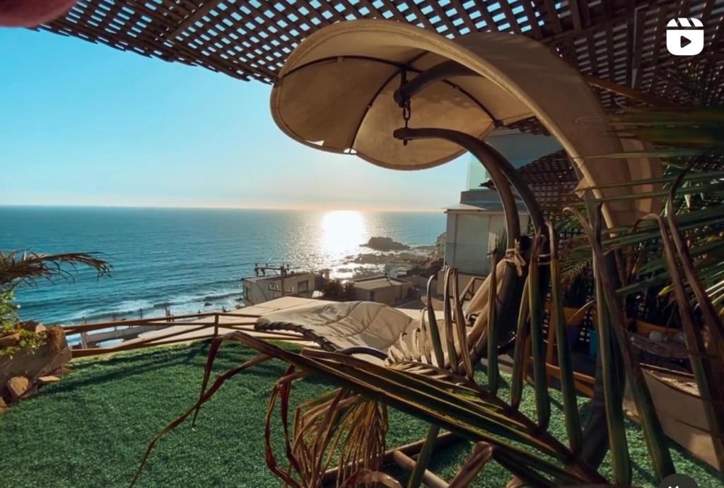 een uitzicht op de oceaan vanuit een resort met een paraplu bij Pacificsunset Reñaca in Viña del Mar