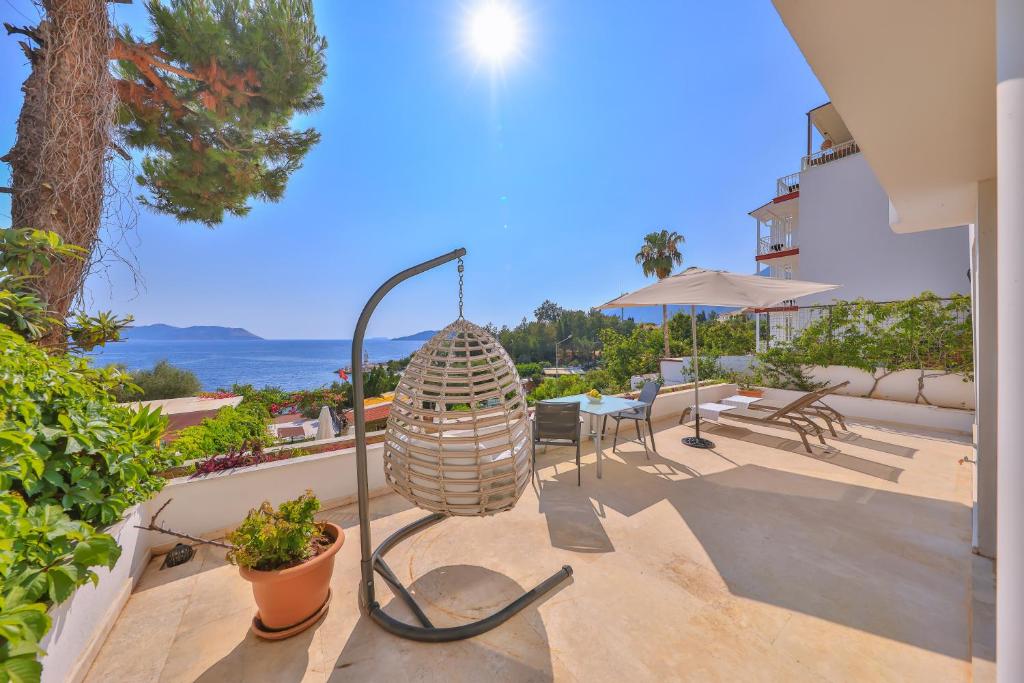 une terrasse avec une lampe, une table et des chaises dans l'établissement Gardenia Hotel, à Kaş