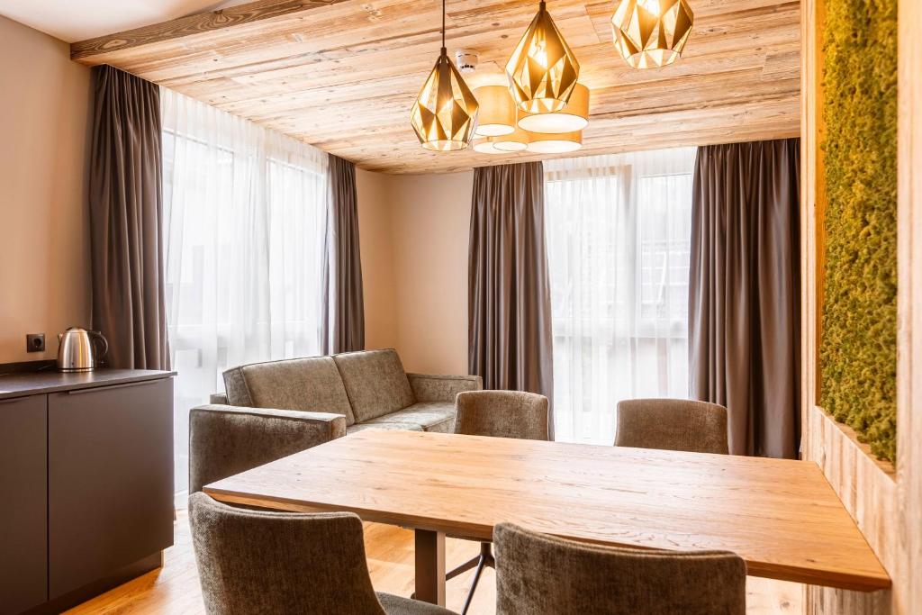 a dining room with a wooden table and chairs at Zillertal Suites Fügen by ALPS RESORTS in Fügen