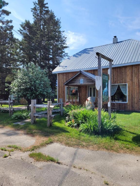 un fienile di legno con un cartello di fronte di Le Gîte Du Gardien Blanc a Saint-David-de-Falardeau