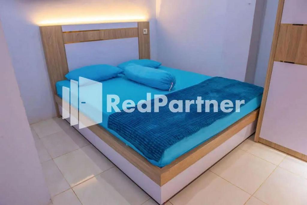 un letto in una camera con un cartello rosso firmato partner di Hotel Rai's Palopo Exclusive Mitra RedDoorz a Palopo