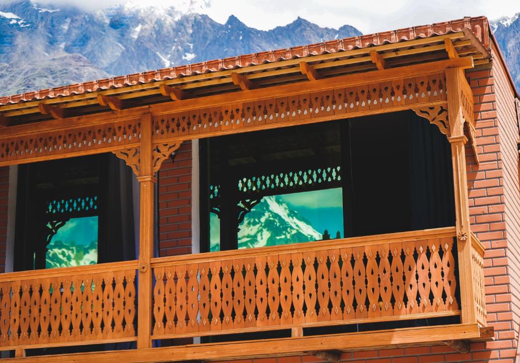 d'un balcon en bois avec des montagnes en arrière-plan. dans l'établissement Fiten house, à Kazbegi