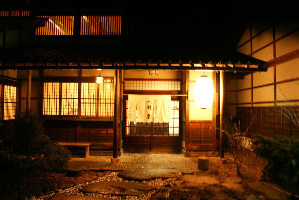 uma entrada para um edifício com luz à noite em Kazeya em Takayama