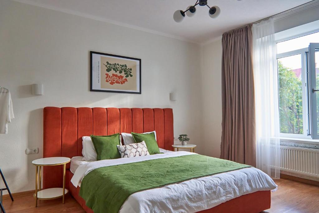 a bedroom with a large bed with a red headboard at Best Apartments on Kyryla & Mefodia in Mukacheve