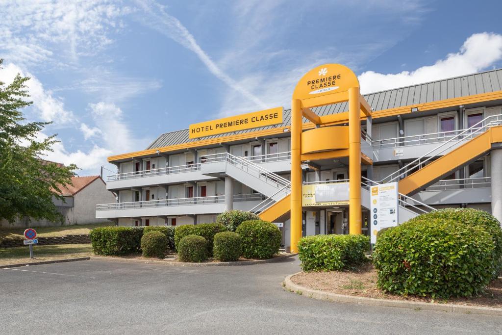 een groot gebouw met een geel en wit gebouw bij Premiere Classe La Ville Du Bois in La Ville-du-Bois