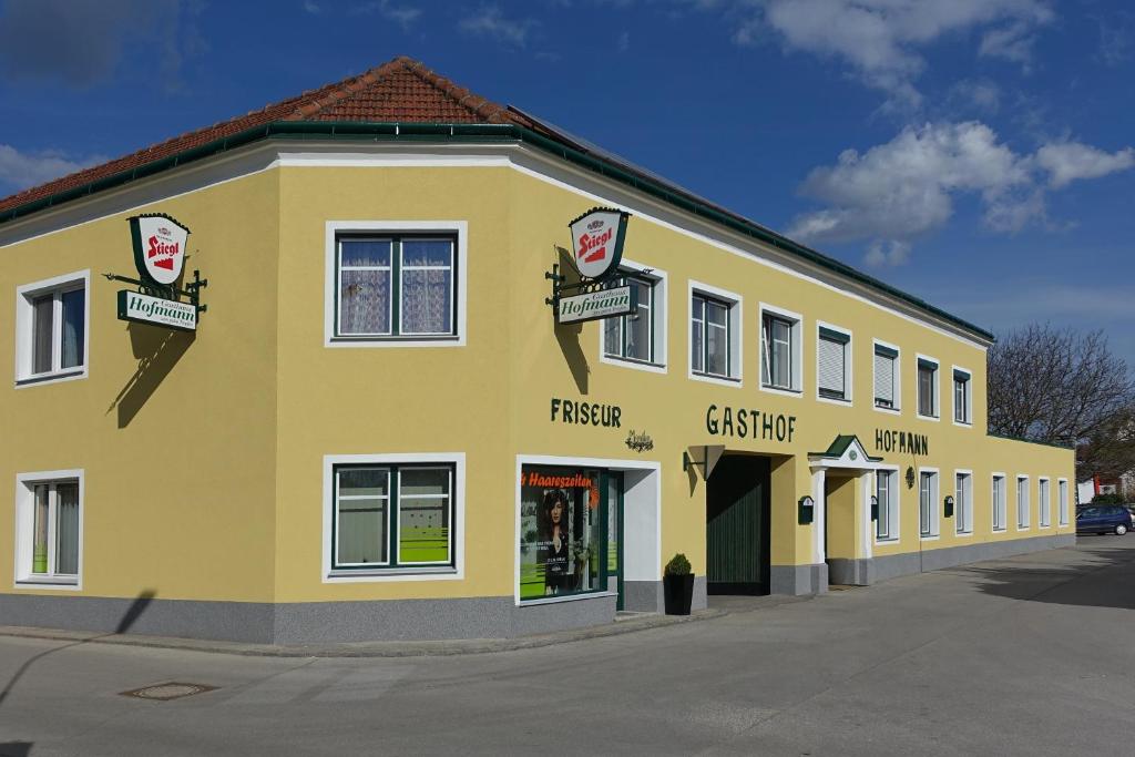 un grande edificio giallo con un negozio di fronte di Hofmanns B&B a Loosdorf