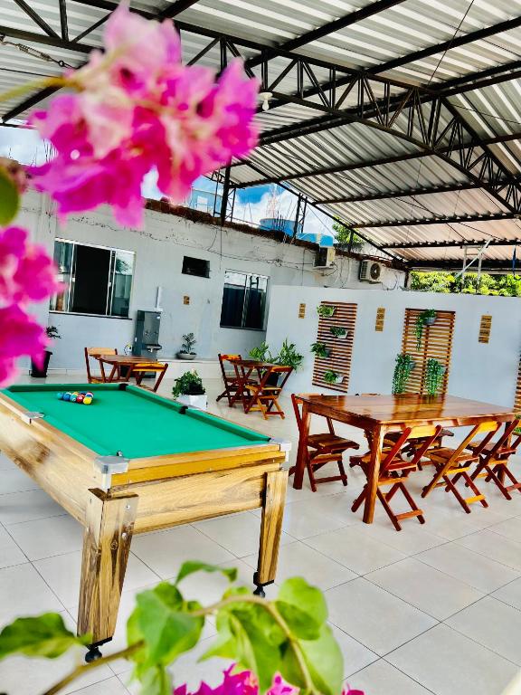 einen Billardtisch in einem Zimmer mit Tischen und Stühlen in der Unterkunft Hostel Meio do Mundo in Macapá