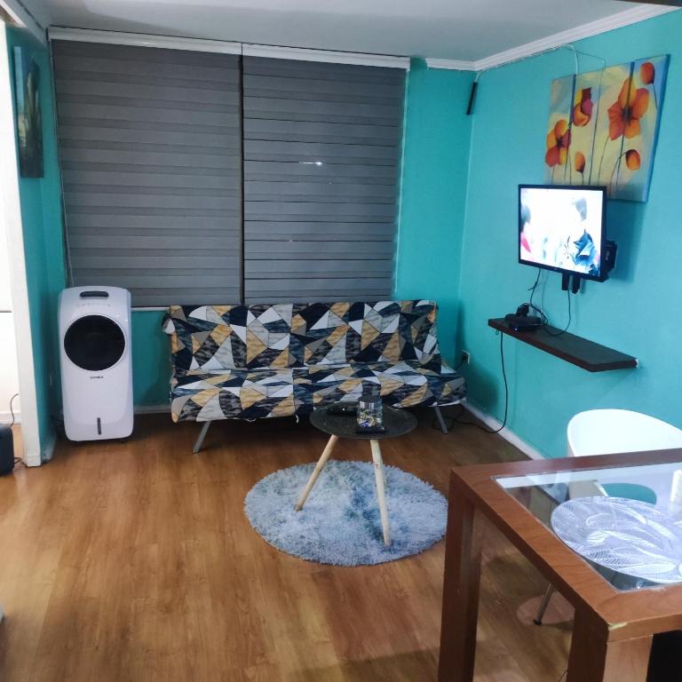 uma sala de estar com um sofá e uma televisão em Departamento Santiago Centro em Santiago