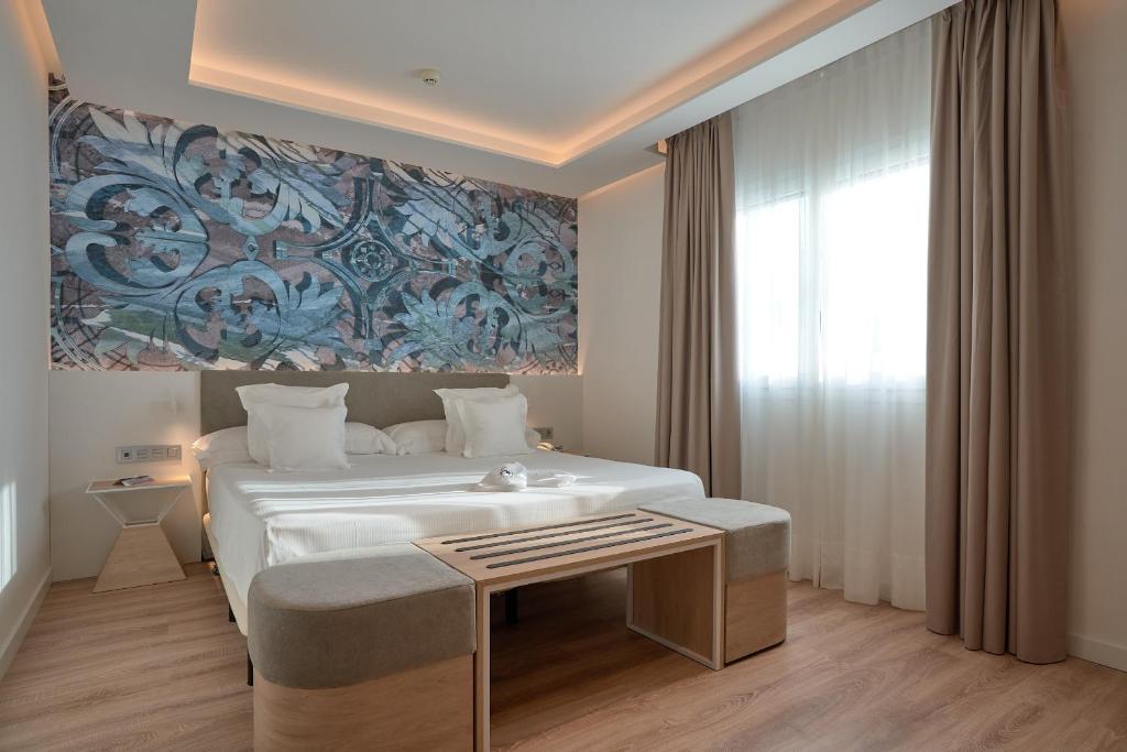 een slaapkamer met een groot wit bed en een raam bij Monte Triana in Sevilla