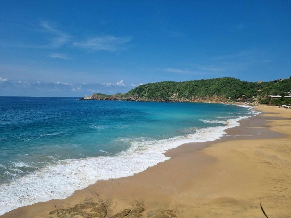 een uitzicht op een strand met de oceaan bij Posada Ziga Playa in Mazunte