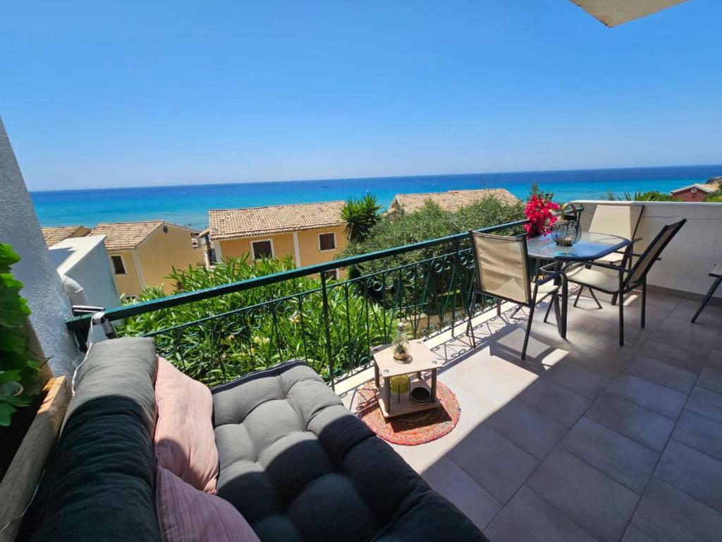 balcone con divano, tavolo e vista sull'oceano di Standart Apartments , Glyfada Beach a Glifada (Glyfada)