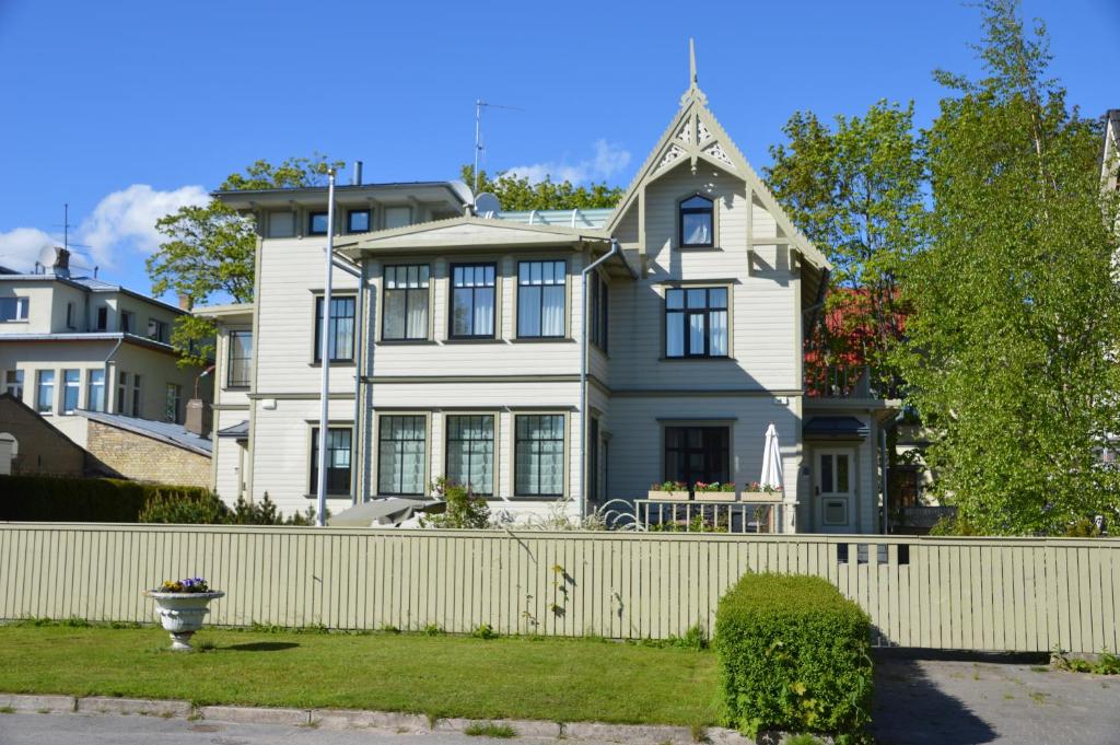 a white house with a white fence at Papli Villa in Pärnu