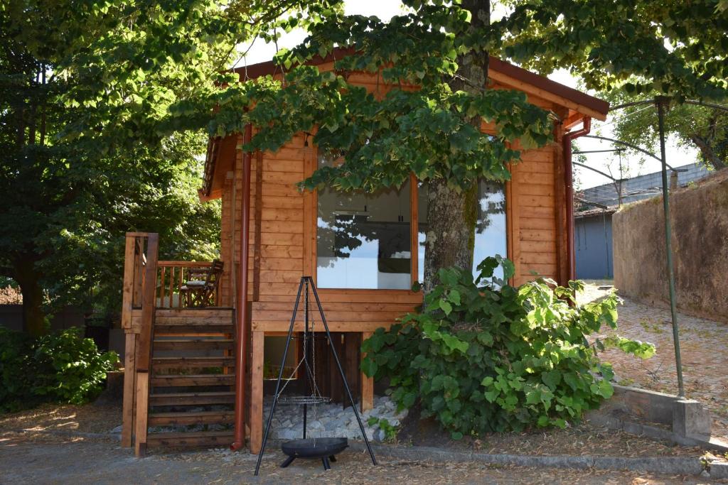 una casetta con un portico e un albero di Refugio D Alecrim a Paredes