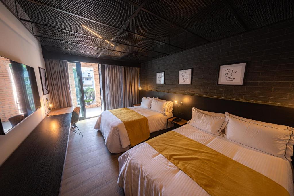 um quarto de hotel com duas camas e uma janela em FULTON Business Luxury HOTEL em Guadalajara