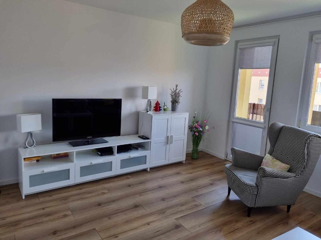 un soggiorno con un centro di intrattenimento bianco e una TV a schermo piatto di Apartament Północna przy Suntago, Deepspot a Mszczonów