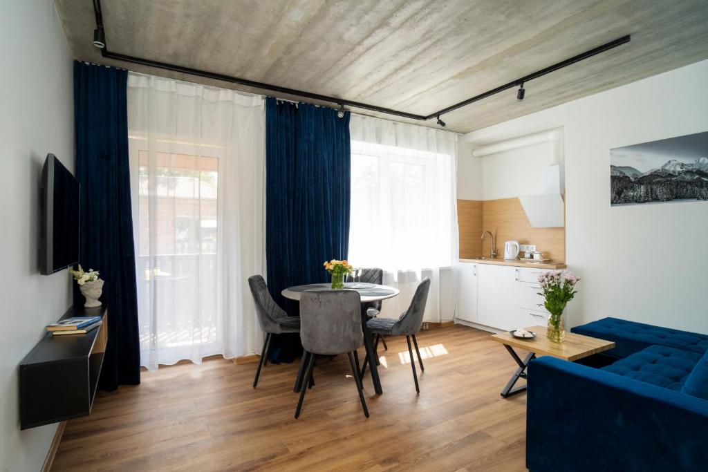 - un salon avec une table et un canapé bleu dans l'établissement Fort63 apartments, à Kaunas