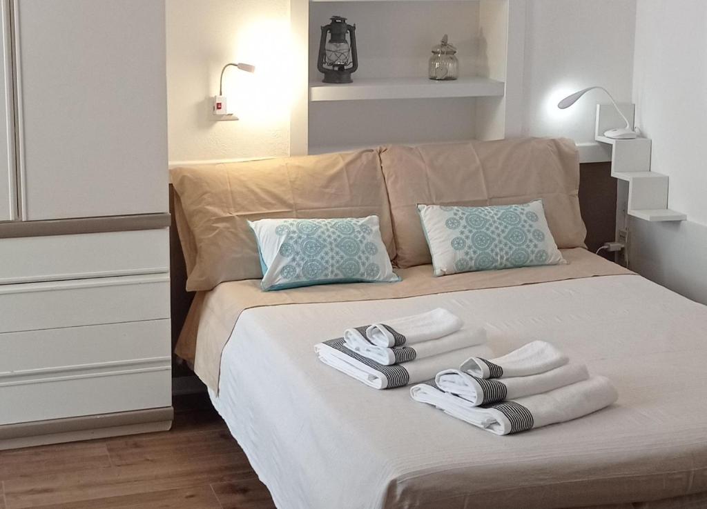 um quarto com uma cama com toalhas em Sa Frummiga em Cagliari