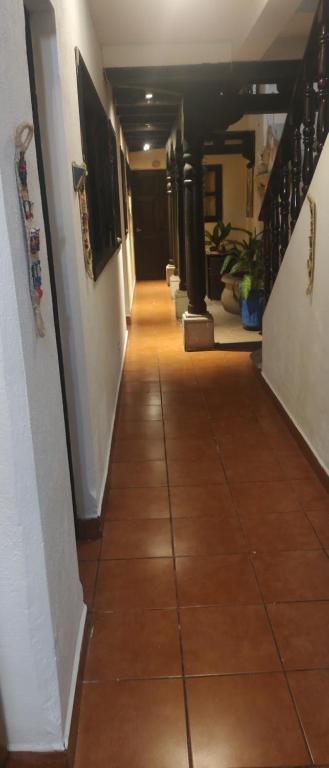 a hallway with a tile floor and stairs in a building at Hotel Vista al Cerro in Antigua Guatemala