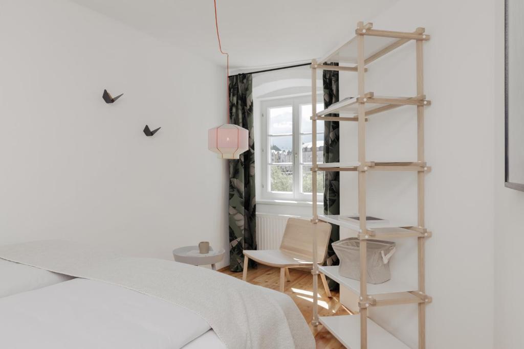 - une chambre avec une étagère à côté d'un lit dans l'établissement Das Grüne Haus - Boutique Apartments ecofriendly, à Innsbruck