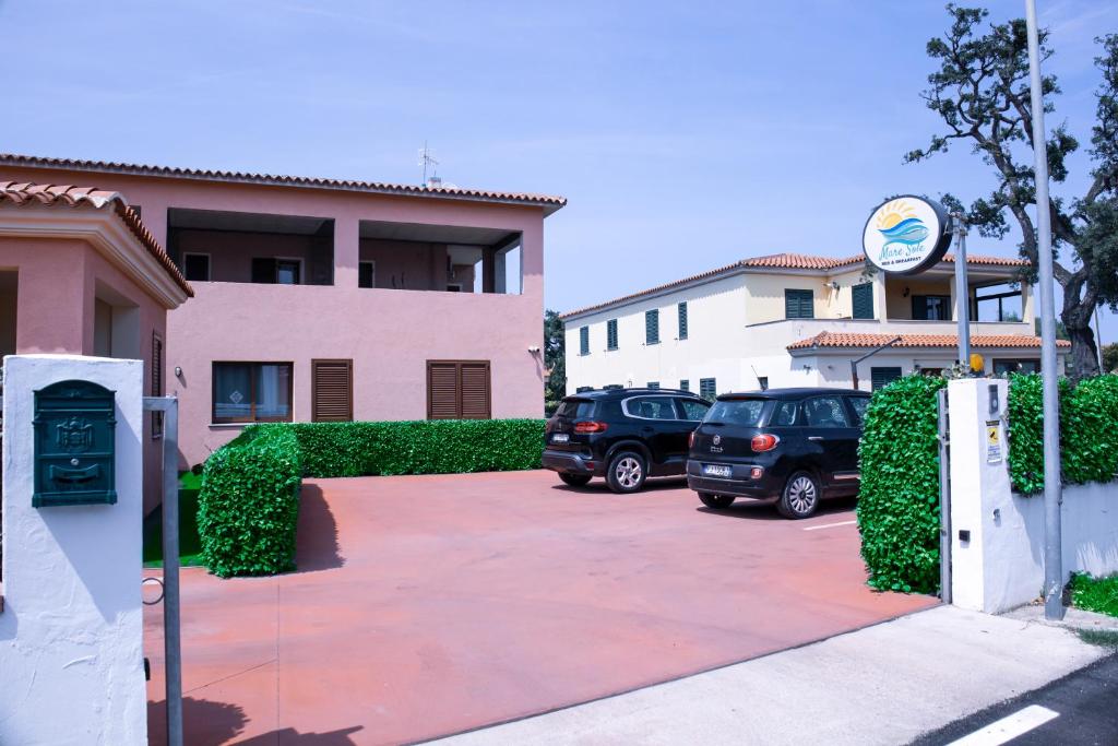 dos autos estacionados en un estacionamiento frente a un edificio en Mare Sole, en San Teodoro