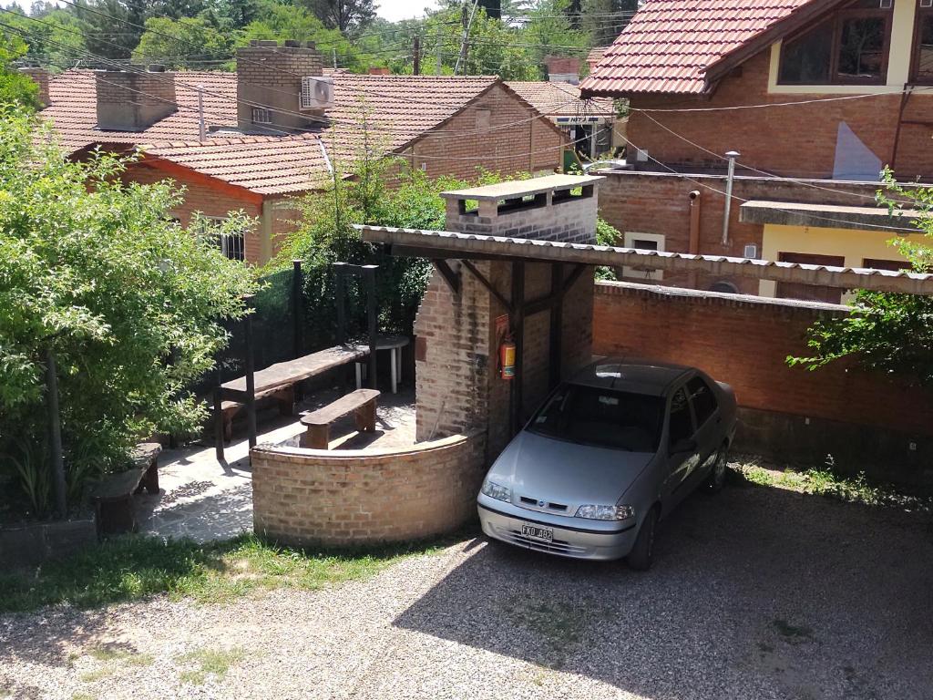 un coche aparcado en un aparcamiento al lado de un edificio en TATOVGB, en Villa General Belgrano