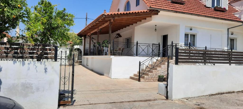 une maison blanche avec une porte et des escaliers pour y accéder dans l'établissement Three Artists Cottage, à Pórto Ráfti