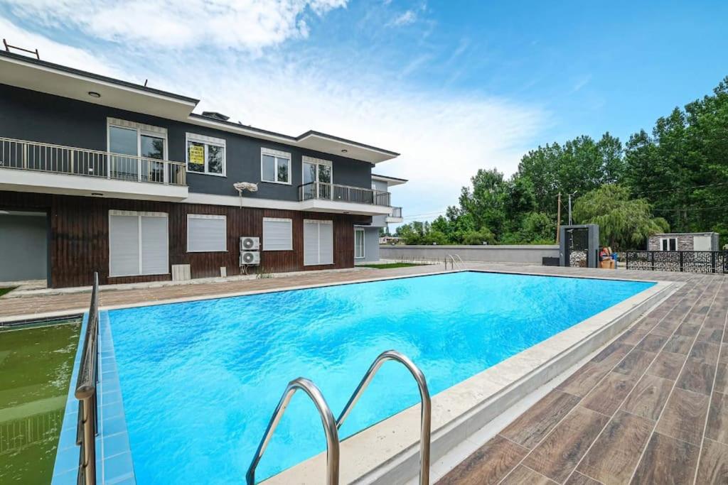 a swimming pool in front of a house at Palmiye Apart Hotel in Antalya